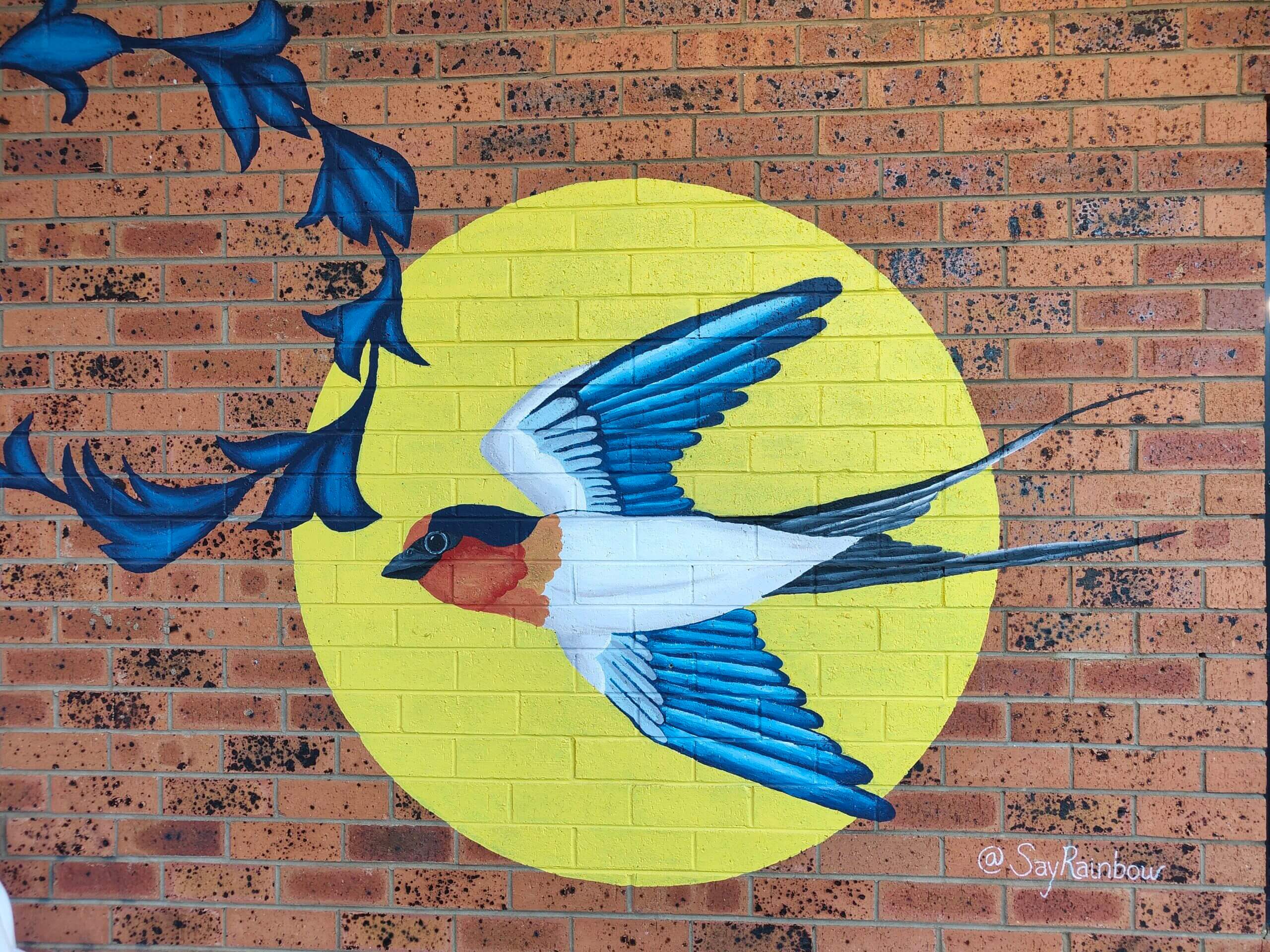 Welcome swallow mural on brick wall in Blaxland